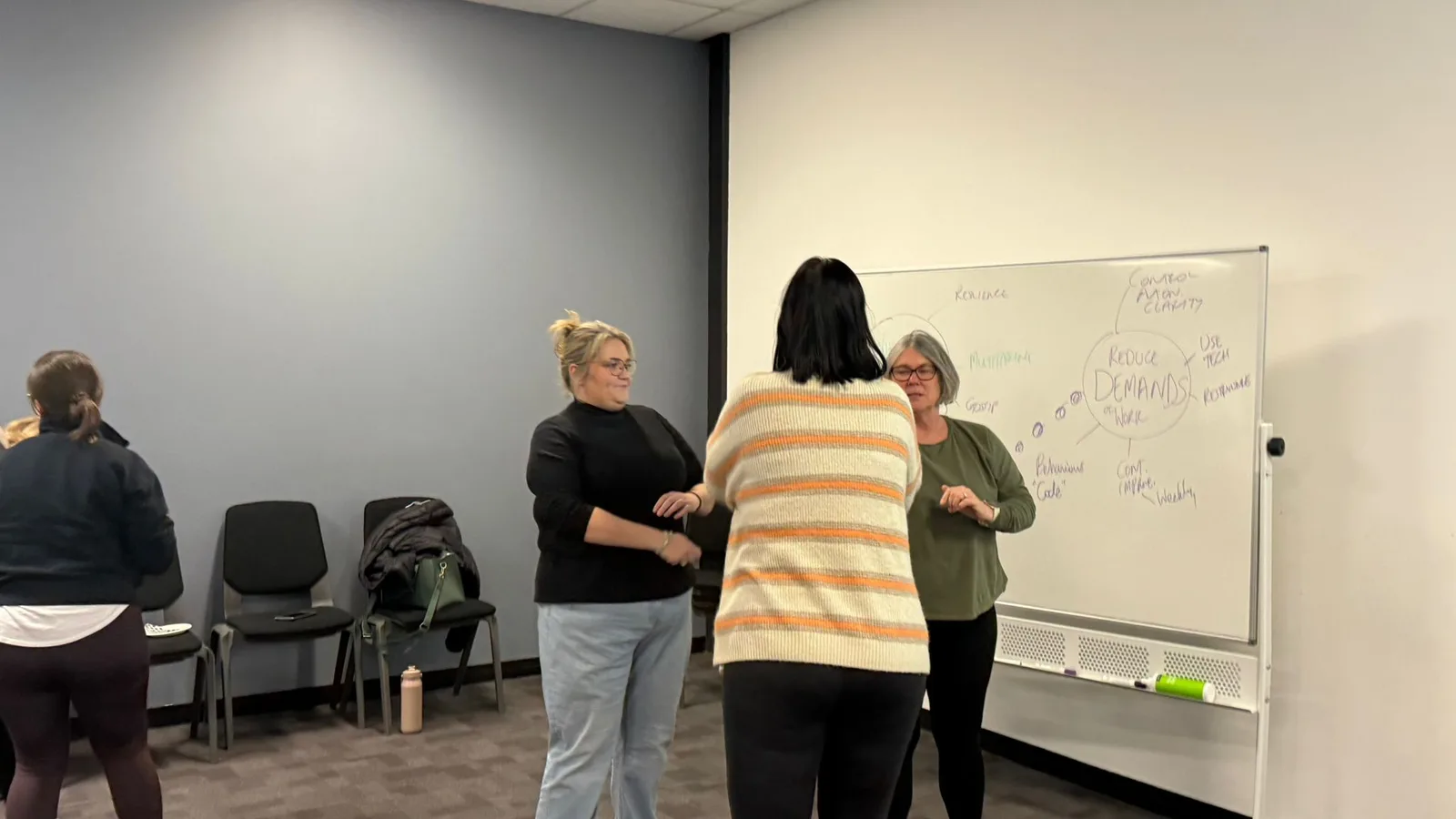 Two participants talk beside a whiteboard during a Personal Safety Program session
